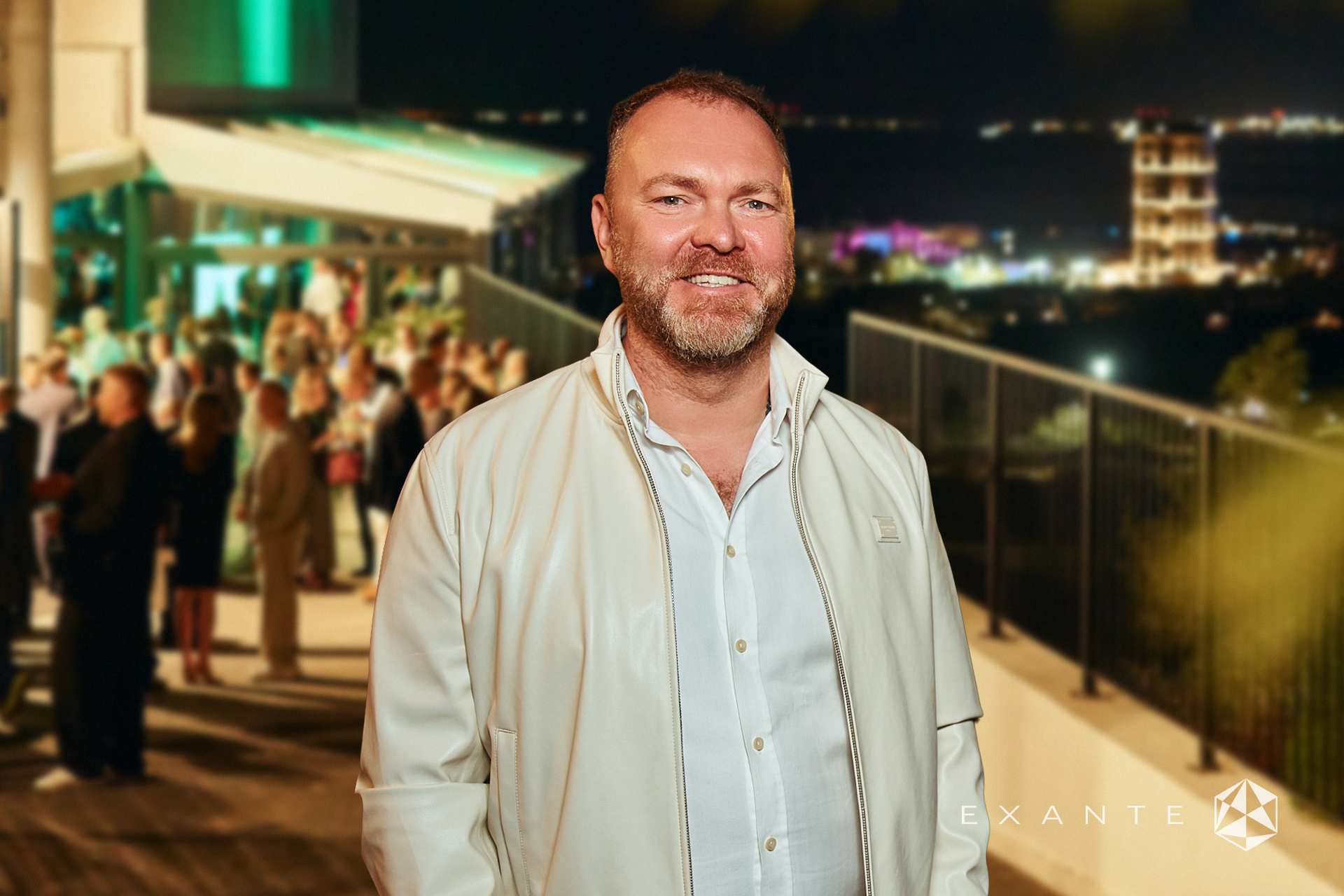 A man in a white jacket and shirt smiles in front of an evening party, featuring the EXANTE logo.